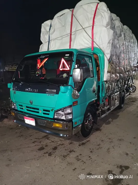 Nighttime Shot of Teal Truck with Tarp in Industrial Setting – AI Generated Video | Hailuo AI