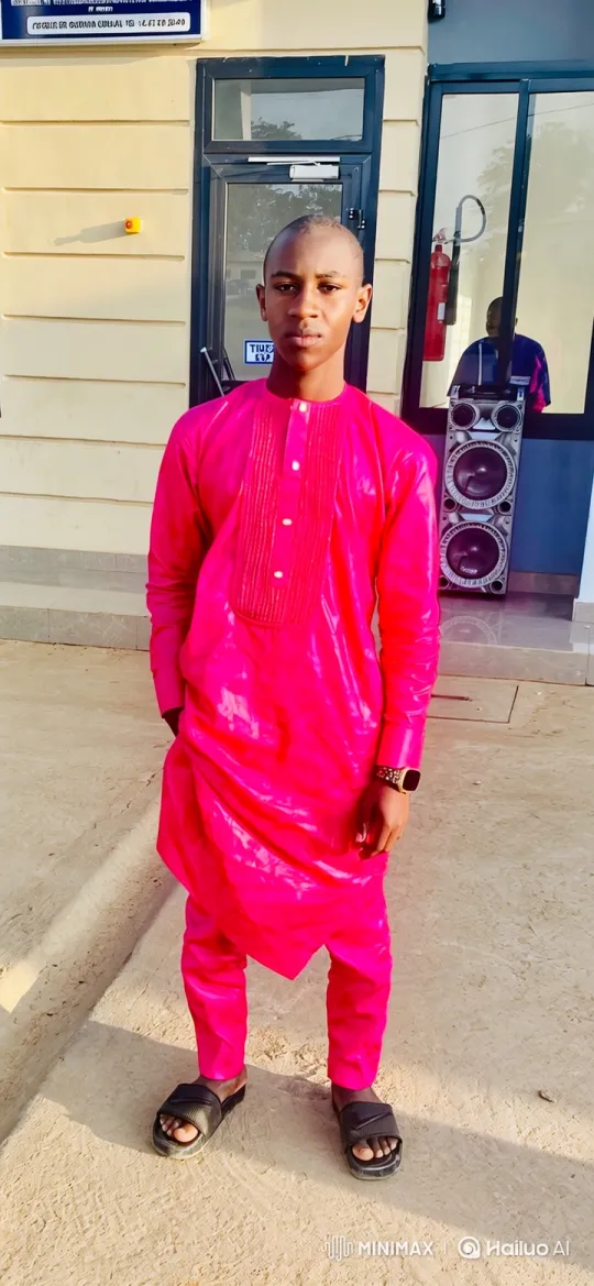Young Man in Bright Pink Outfit Stands Calmly Outside Building – AI Generated Video | Hailuo AI