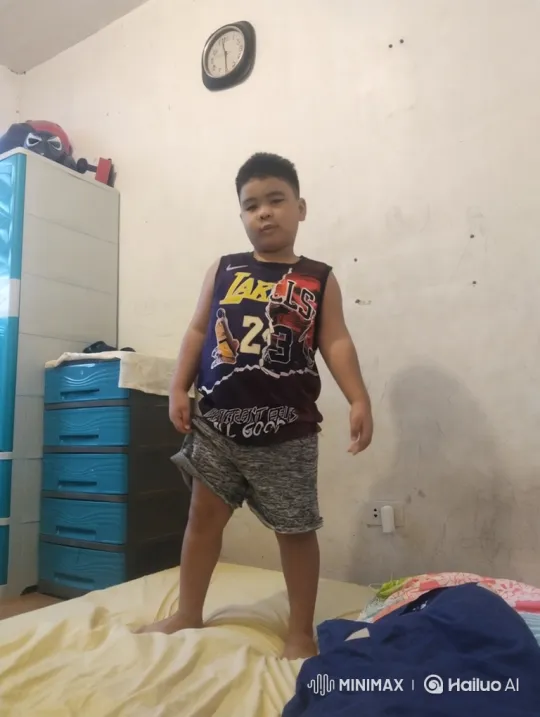 Young Boy Joyfully Jumps on Bed, Falls with Amused Look – AI Generated Video | Hailuo AI