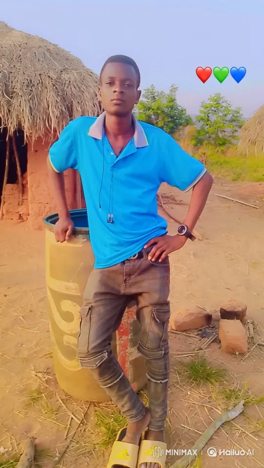 Young Man Poses by Hut in Rural Landscape – AI Generated Video | Hailuo AI