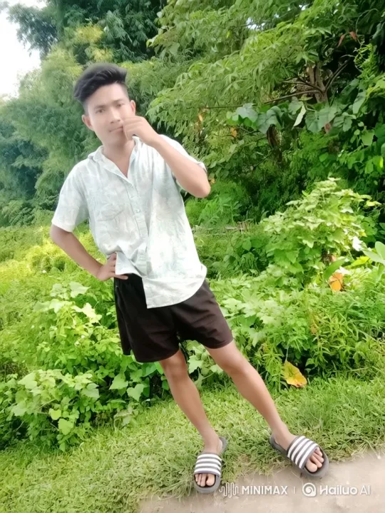 Young Man Poses Thoughtfully in Lush Greenery – AI Generated Video | Hailuo AI