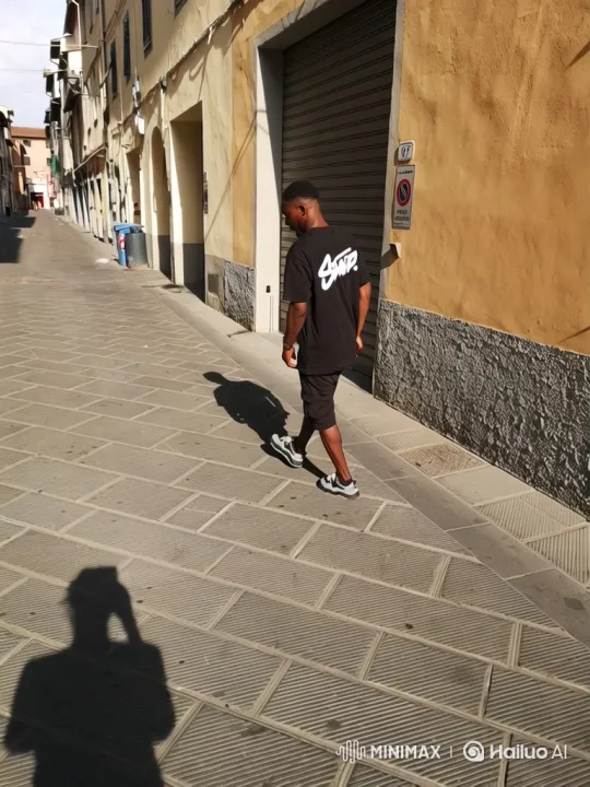 Young Man Walking Down Sunlit Historic Street – AI Generated Video | Hailuo AI