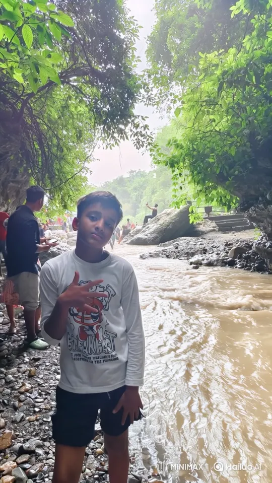 Young Boy Poses by a Rushing River Amidst Nature – AI Generated Video | Hailuo AI