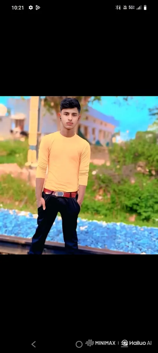 Young Man in Orange Shirt Stands by Railway Track – AI Generated Video | Hailuo AI