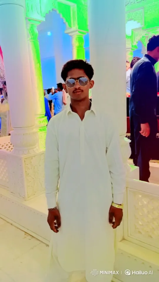 Young Man in Bright Hall Stands Calmly Amid Gentle Activity – AI Generated Video | Hailuo AI