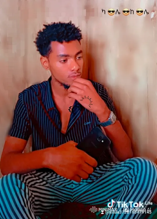 Young Man in Striped Clothing Contemplates with Smartphone – AI Generated Video | Hailuo AI