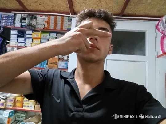 Young Man Reveals Face in Calm Shop Setting – AI Generated Video | Hailuo AI