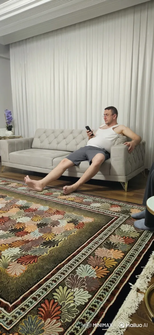 Man Relaxing on Sofa, Engaged with Smartphone – AI Generated Video | Hailuo AI