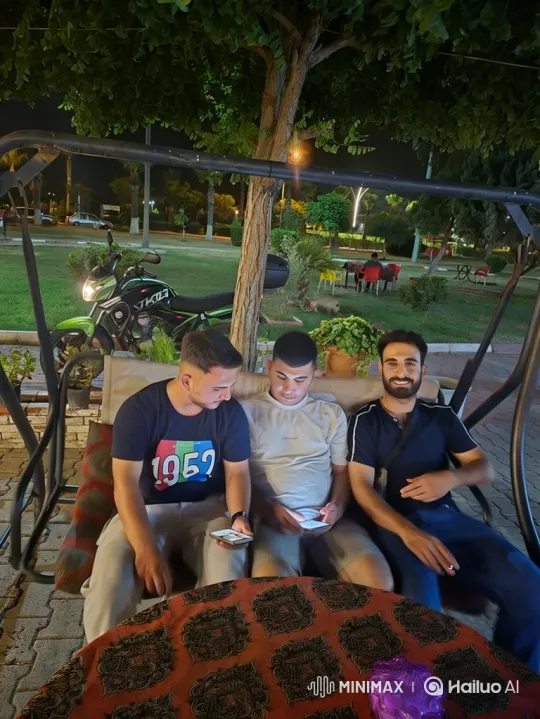 Night Park Scene: Men on Swing, Smiling and Smartphones – AI Generated Video | Hailuo AI