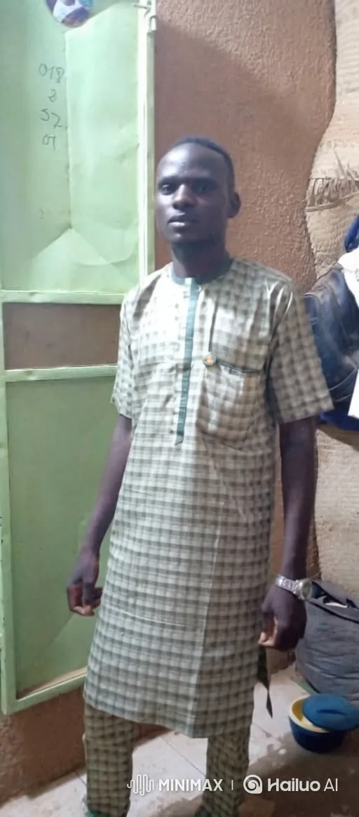 Man in Checkered Outfit Stands Still, Smiles Slightly – AI Generated Video | Hailuo AI