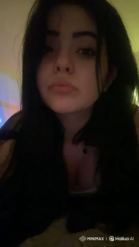Young Woman's Subtle Smile in Dimly Lit Room – AI Generated Video | Hailuo AI